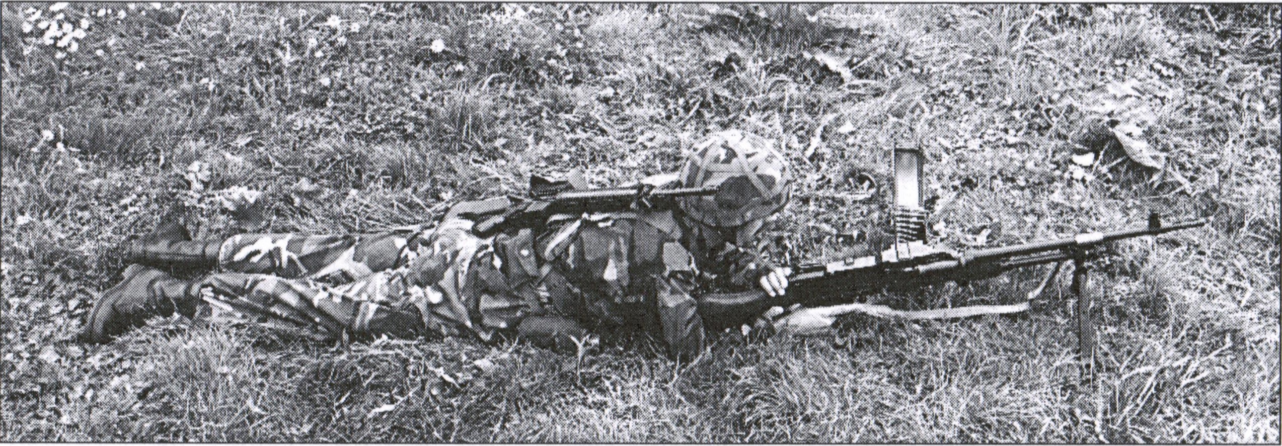An MAG-gunner with a slung Diemaco on his back